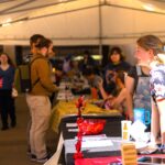 Young woman leans on table at event
