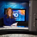 Former KTVL news director Trish Glose sits at a broadcast desk