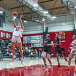 Surrounded by opposing players, SOU freshman guard Millie Day shoots from the key in a game with Simpson University