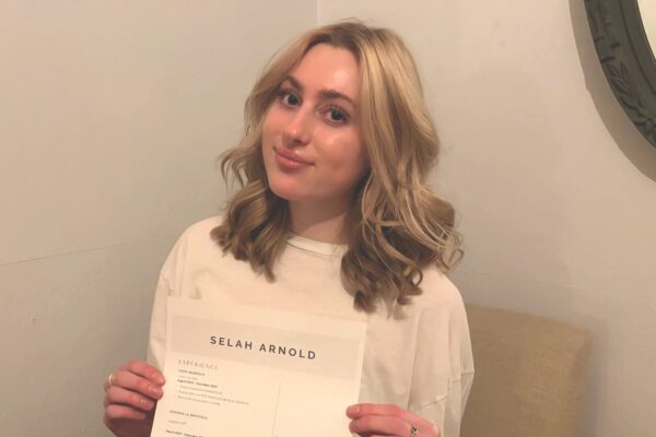 Young woman holds document with resume