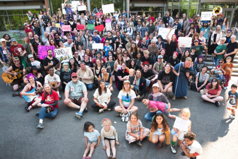 Approximately 100-200 people gather with protest signs in front of Southern Oregon University's Hannon Library